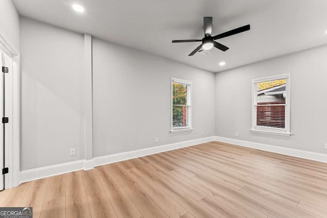 empty room with ceiling fan and light hardwood / wood-style flooring