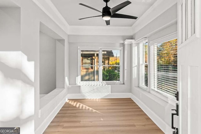 unfurnished sunroom featuring ceiling fan