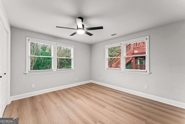 spare room featuring ceiling fan, plenty of natural light, and light wood-type flooring