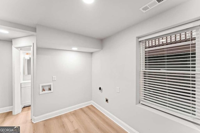 washroom with hookup for a washing machine, light wood-type flooring, and electric dryer hookup