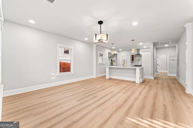 unfurnished living room with light wood-type flooring and sink