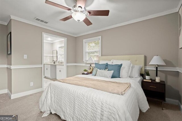 carpeted bedroom featuring ceiling fan, ornamental molding, and ensuite bathroom