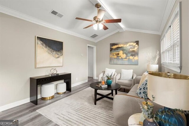 living room with lofted ceiling with beams, crown molding, and wood-type flooring