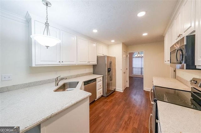 kitchen featuring stainless steel appliances, dark wood-type flooring, sink, white cabinets, and hanging light fixtures