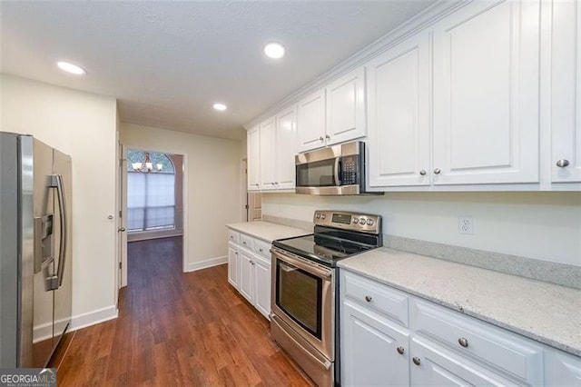 kitchen with white cabinets, light stone counters, dark hardwood / wood-style flooring, and stainless steel appliances