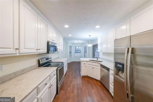 kitchen featuring white cabinetry, stainless steel appliances, and decorative light fixtures