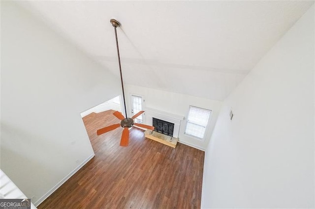 living room with ceiling fan, lofted ceiling, and dark wood-type flooring