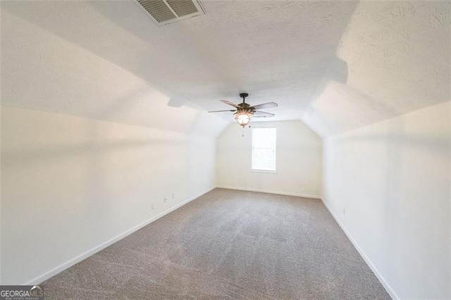 bonus room featuring carpet flooring, lofted ceiling, and a textured ceiling