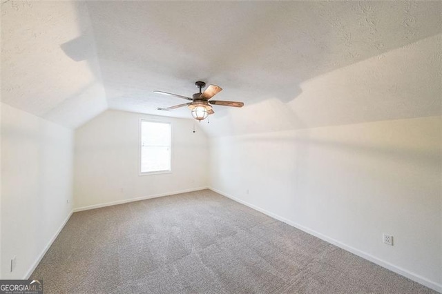 bonus room featuring ceiling fan, lofted ceiling, a textured ceiling, and carpet floors