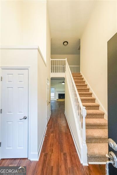 stairway featuring a towering ceiling and hardwood / wood-style flooring