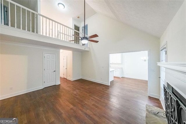 unfurnished living room with ceiling fan, dark hardwood / wood-style flooring, high vaulted ceiling, and a textured ceiling