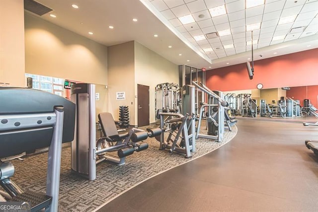 gym with a towering ceiling and a paneled ceiling