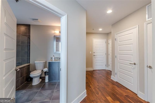 bathroom with wood-type flooring, vanity, and toilet