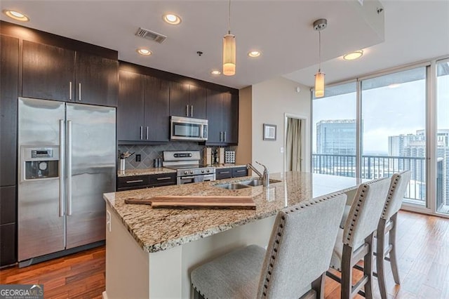 kitchen featuring a wealth of natural light, pendant lighting, stainless steel appliances, and sink