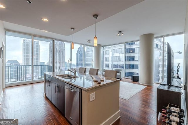 kitchen with light stone counters, pendant lighting, stainless steel dishwasher, and dark hardwood / wood-style floors