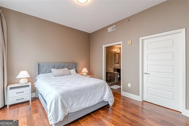 bedroom featuring hardwood / wood-style floors and ensuite bath