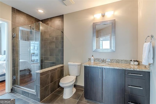 bathroom with tile patterned floors, vanity, toilet, and walk in shower