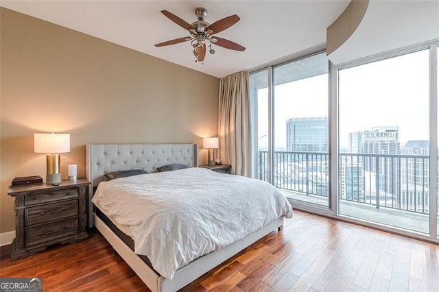 bedroom featuring ceiling fan, expansive windows, wood-type flooring, and access to outside