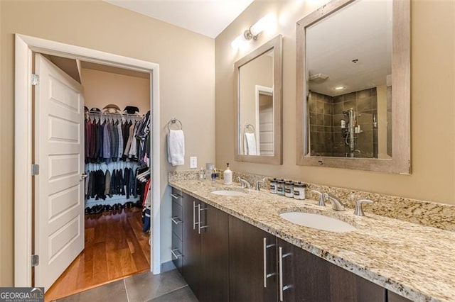 bathroom with vanity, wood-type flooring, and tiled shower