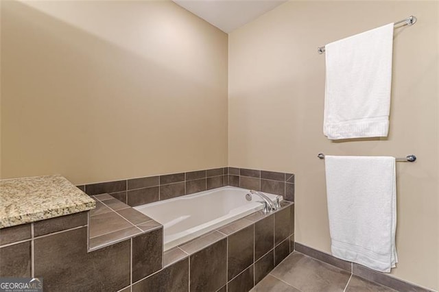 bathroom featuring tile patterned flooring and a relaxing tiled tub