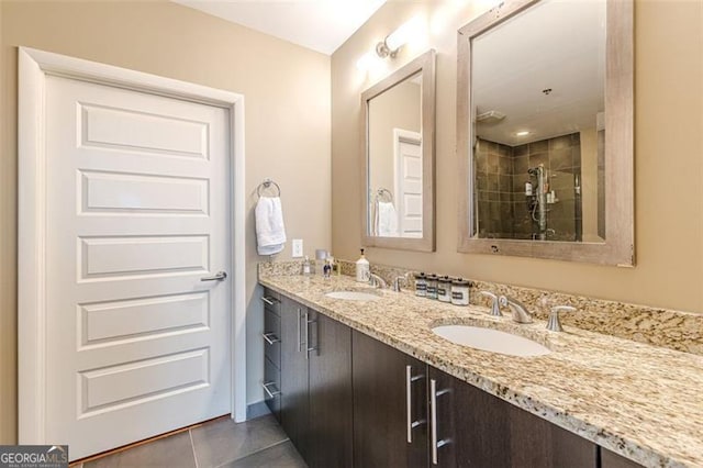 bathroom with tiled shower, vanity, and tile patterned floors