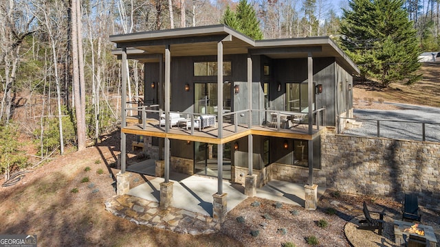 rear view of property featuring a patio area and a wooden deck