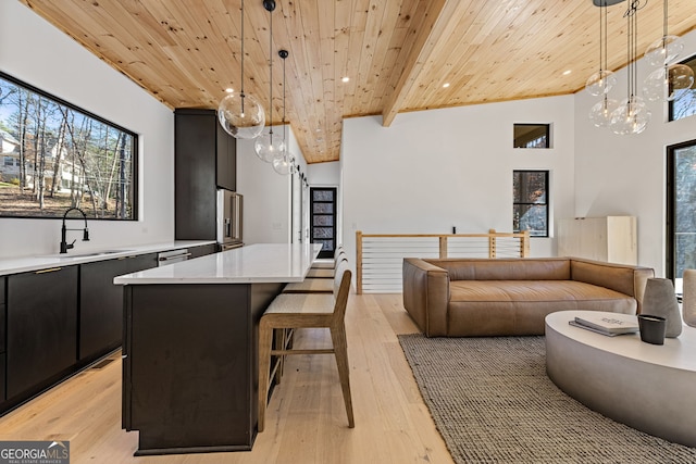 interior space featuring light wood-type flooring, wooden ceiling, sink, and hanging light fixtures