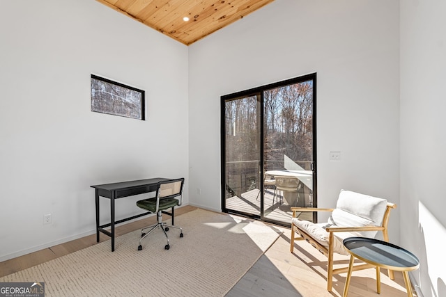 office area with a high ceiling, light hardwood / wood-style flooring, and wood ceiling