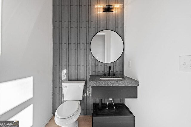 bathroom featuring tasteful backsplash, sink, and toilet