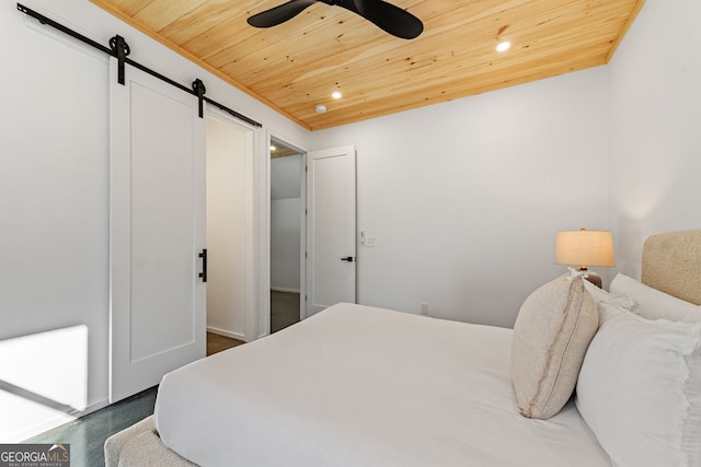 bedroom with a barn door, ceiling fan, and wooden ceiling