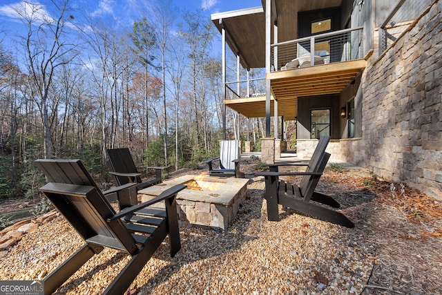 view of patio / terrace featuring a balcony and an outdoor fire pit