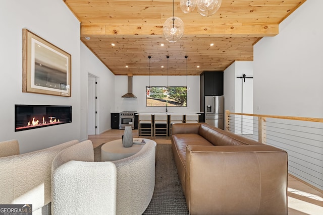 living room with vaulted ceiling with beams, light hardwood / wood-style flooring, and wood ceiling