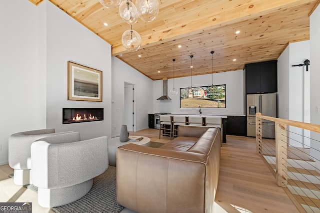 living room with lofted ceiling, light wood-type flooring, wood ceiling, and sink