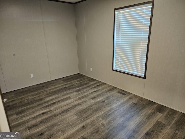 unfurnished room with dark hardwood / wood-style flooring