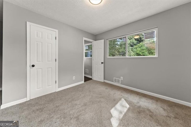 unfurnished bedroom with carpet floors and a textured ceiling