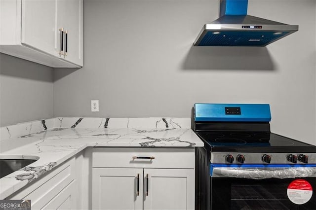 kitchen with light stone countertops, extractor fan, white cabinets, and stainless steel electric range