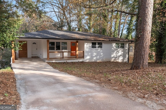 ranch-style home featuring a carport and covered porch