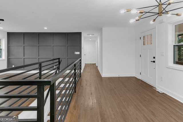 foyer with wood-type flooring and a notable chandelier