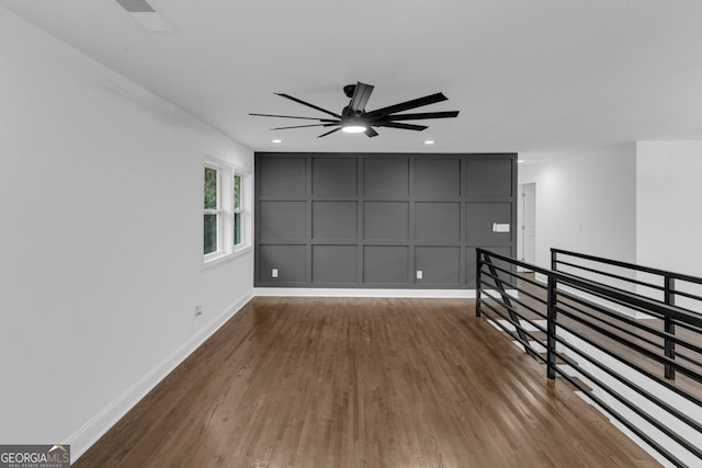 unfurnished room with ceiling fan and hardwood / wood-style flooring