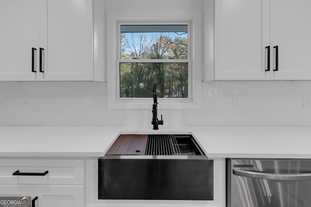 interior details featuring dishwasher, tasteful backsplash, white cabinetry, and sink