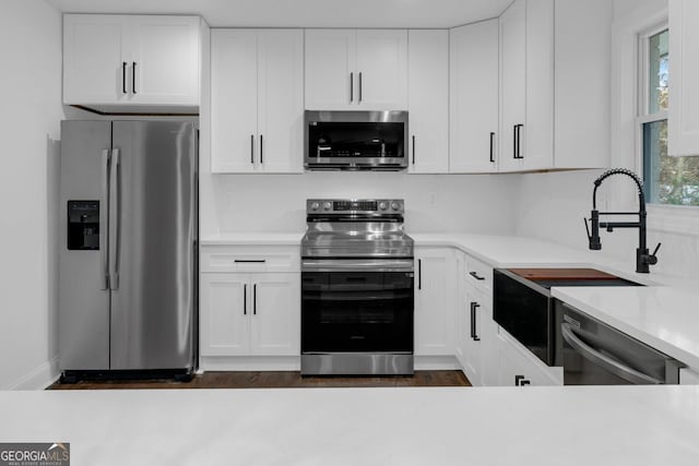 kitchen with white cabinets, appliances with stainless steel finishes, and sink