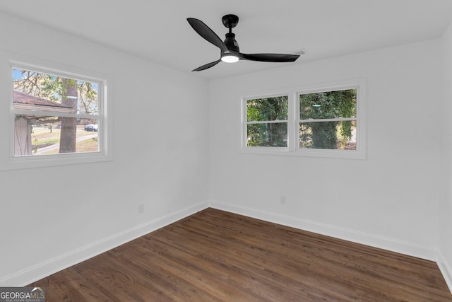 empty room with ceiling fan and dark wood-type flooring