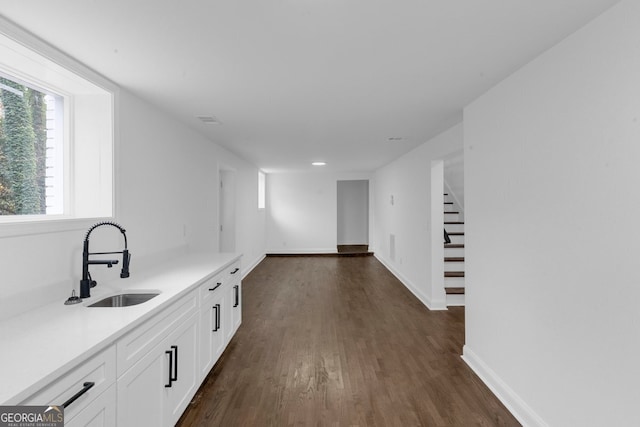 interior space featuring dark hardwood / wood-style floors, white cabinetry, and sink