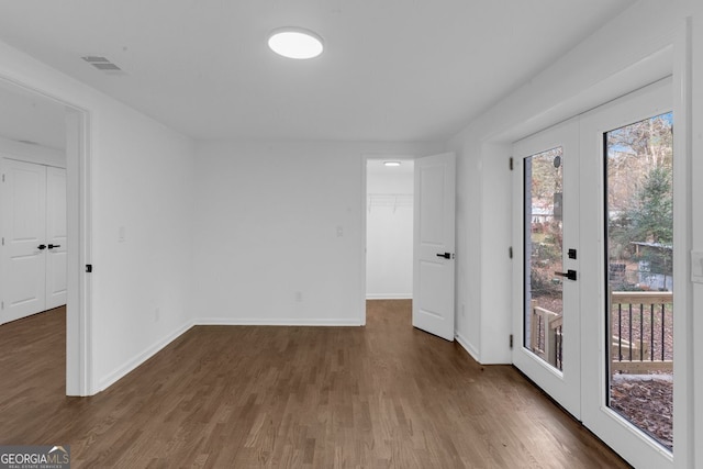 empty room with dark hardwood / wood-style flooring and french doors