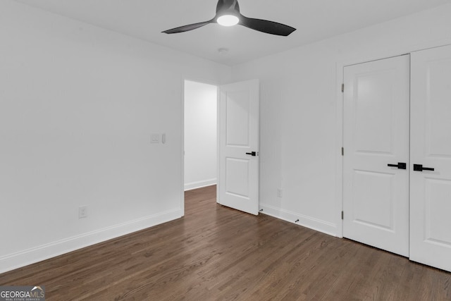 unfurnished bedroom featuring dark hardwood / wood-style flooring, a closet, and ceiling fan