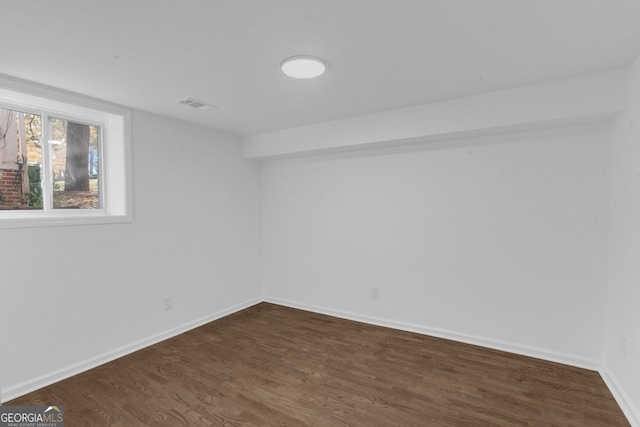 unfurnished room with dark hardwood / wood-style flooring