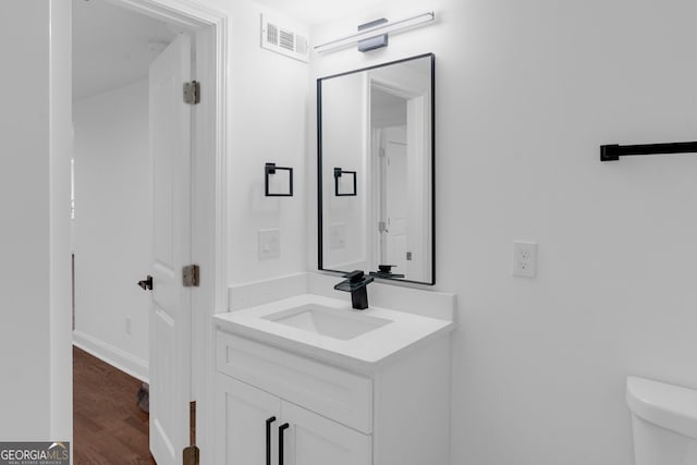 bathroom featuring hardwood / wood-style flooring, vanity, and toilet