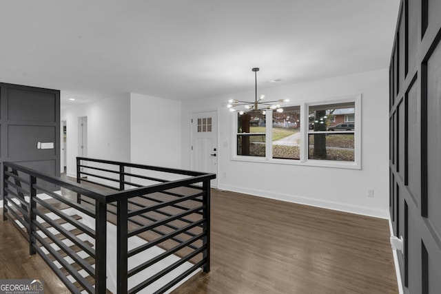 unfurnished dining area with dark hardwood / wood-style flooring and a notable chandelier