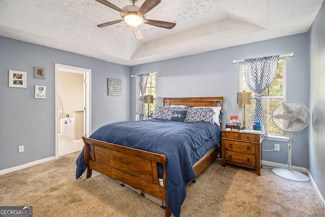 bedroom featuring a raised ceiling, carpet, baseboards, and a textured ceiling