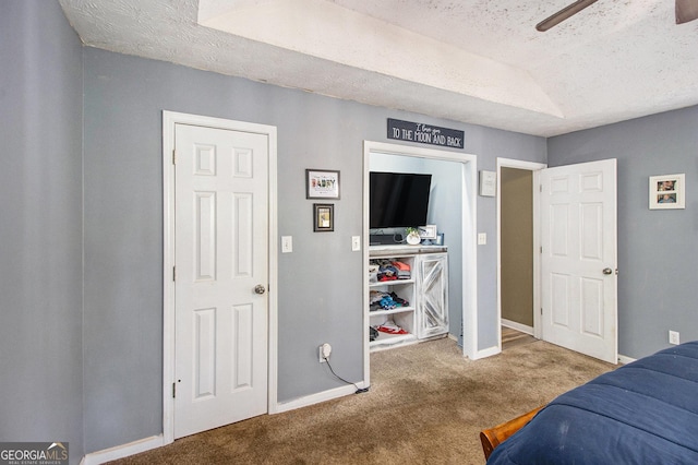 carpeted bedroom with ceiling fan, baseboards, and a textured ceiling